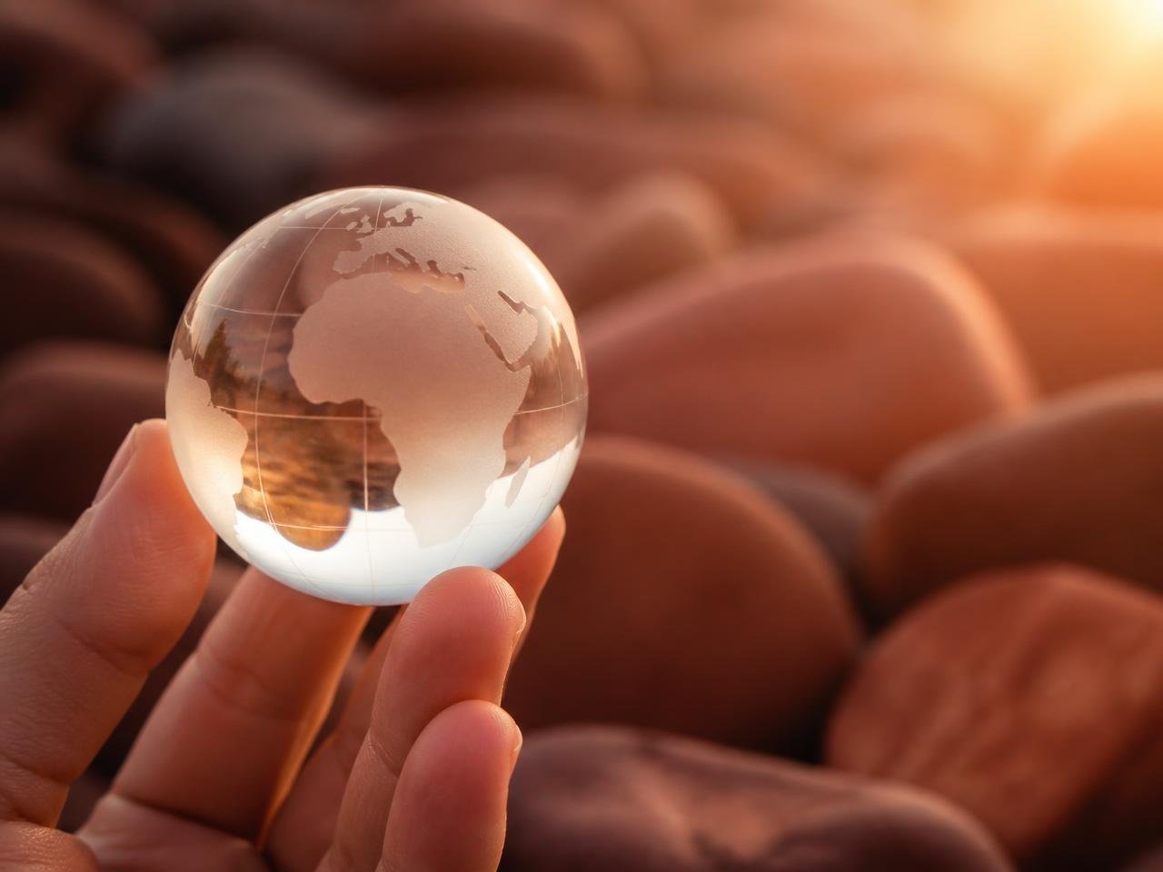 Hand holding a small glass globe symbolising global business reach